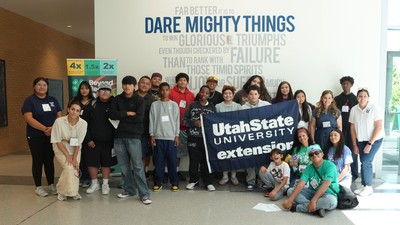 People in a group photo holding a sign that says USU Extension.