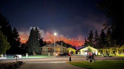 Wildfire burning behind a residential neighborhood.