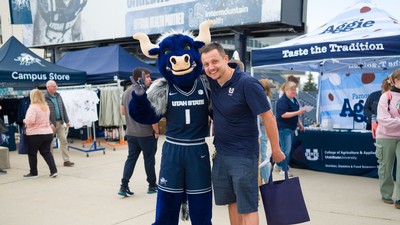 A person posing for a photo with the bull sports mascot Big Blue.