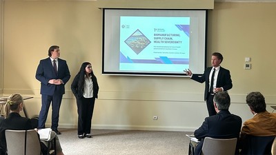A group of students stand in front of a conference room giving a presentation