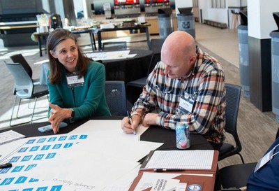 Jake Powell and Stephanie Frohman working at a conference.
