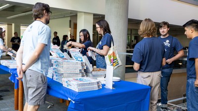 People getting pizza at an event.