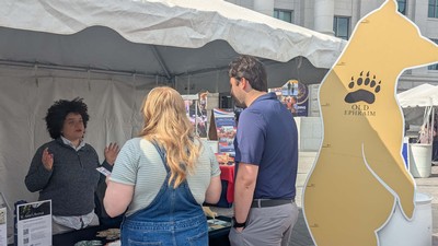 People speaking at an outdoor museum event.