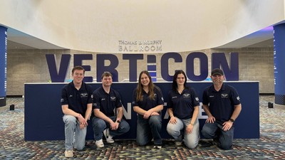 People posing in front of a sign that says "Verticon."