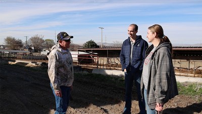 Three people speaking on a farm in rural Utah.