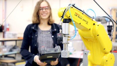 A female student uses a robotic arm machine.