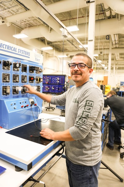 A male student uses an electrical switchboard