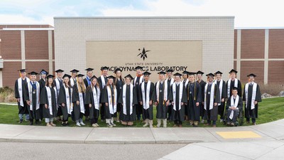 People in graduation robes posing for a group photo.