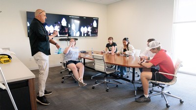 A teacher and students in a conference room.
