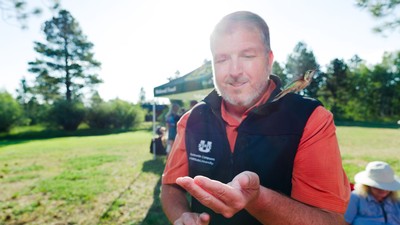 A hummingbird flying from the hands of USU administrator James Taylor.