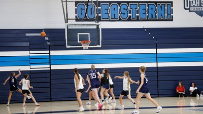 People playing basketball. Sign reads: Go Eastern!