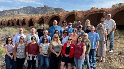 People pose at a historic industrial site.
