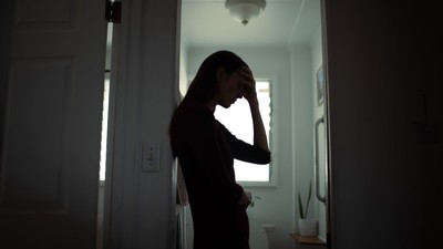 A woman holding her head in her hand.