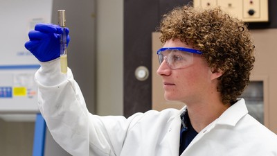 A scientist examining a sample in a test tube.