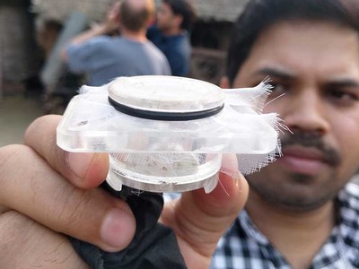 Scientist holding jar of sand flies