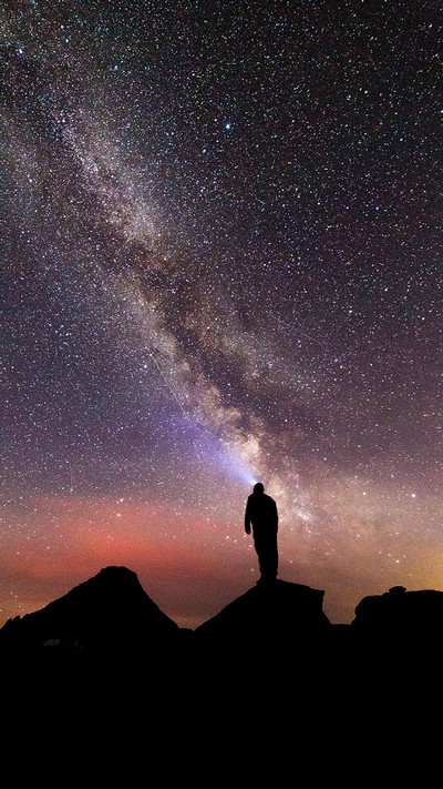 Person looking into the stars above Waterton-Glacier park.
