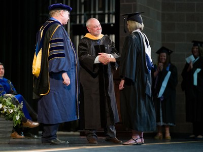 Graduate shakes hands with leader