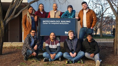 Researchers stand around a sign reading