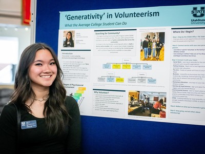 A woman poses in front of a poster that documents her research.