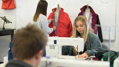 student at a sewing machine.