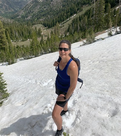 A woman poses for a photo while hiking.