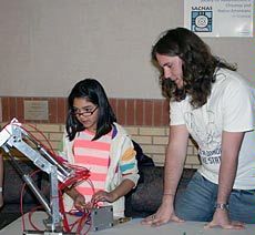 A USU student at a Science Unwrapped event with a young participant