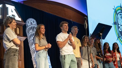 Students stand on a stage