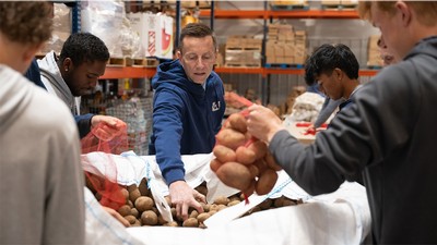 USU President Mortensen and USU Athletes bag potatoes at Cache Valley Community Food Pantry