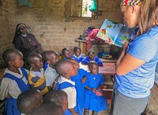USU student Deserey Crowther reading to a group of young people in Uganda
