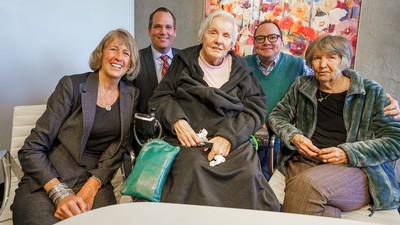 A group of people seated at a table pose for a photograph.