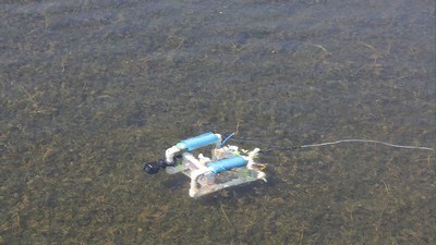 Robot submerged in water with a GoPro attached for filming.