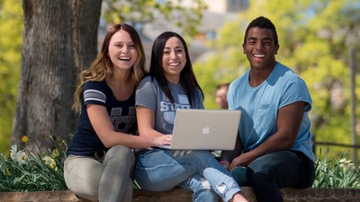 Three USU students pose for a picture with a computer.