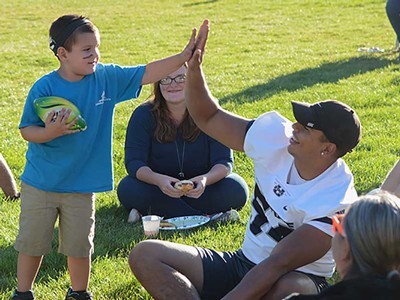 USU football players with Sound Beginnings students