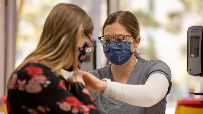USU student receiving a vaccine from a USU Nursing student.