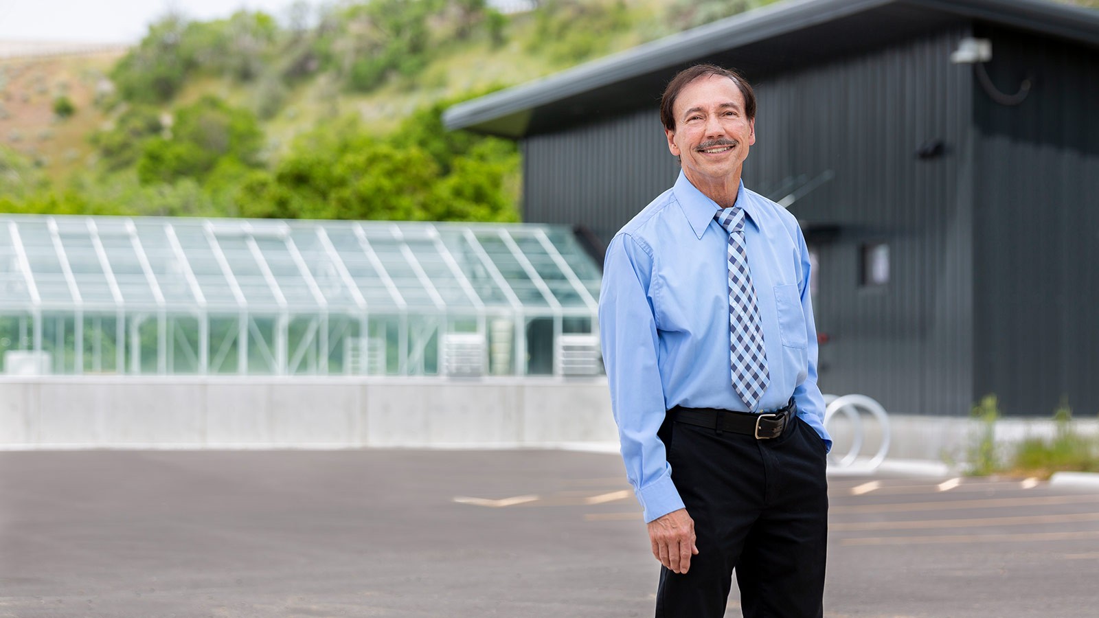 Ron Sims poses for a photo outside USU's Algae Processing and Products Facility.