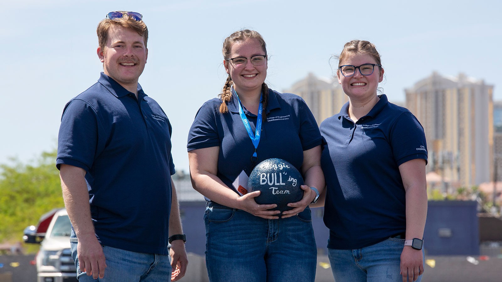 Engineering students hold a concrete ball with Aggie BULL-ing Team written on it.