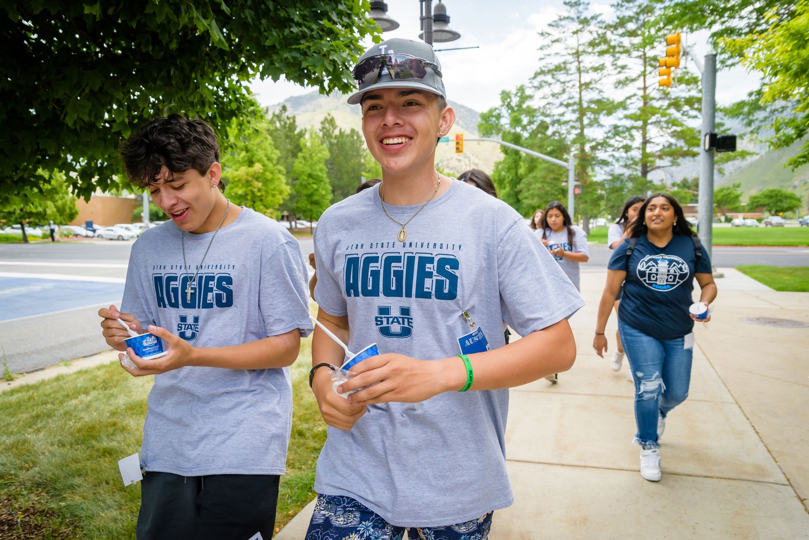 High school students eat Aggie Ice Cream as they walk across the USU Logan campus.