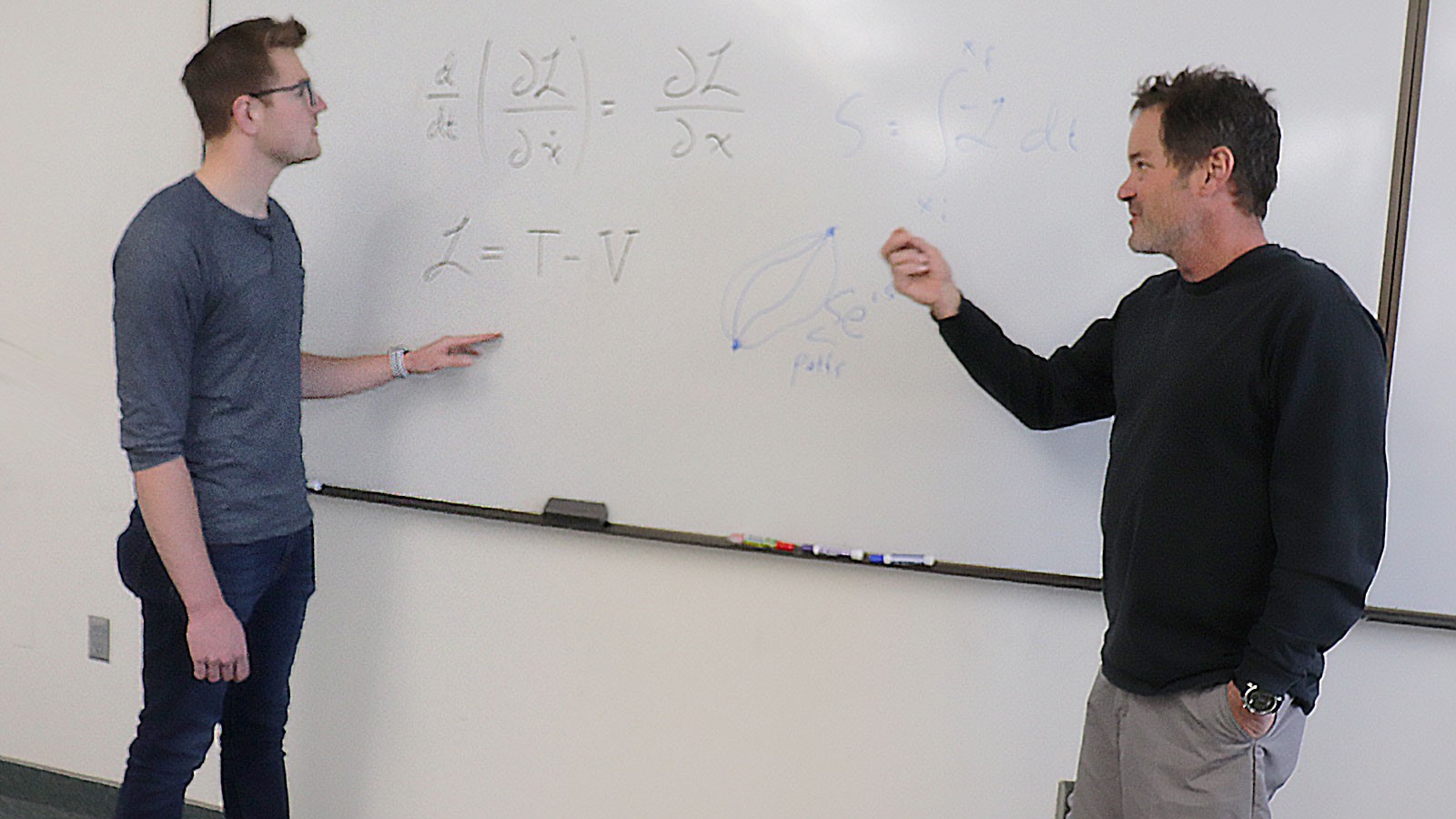 Physicists at whiteboard.