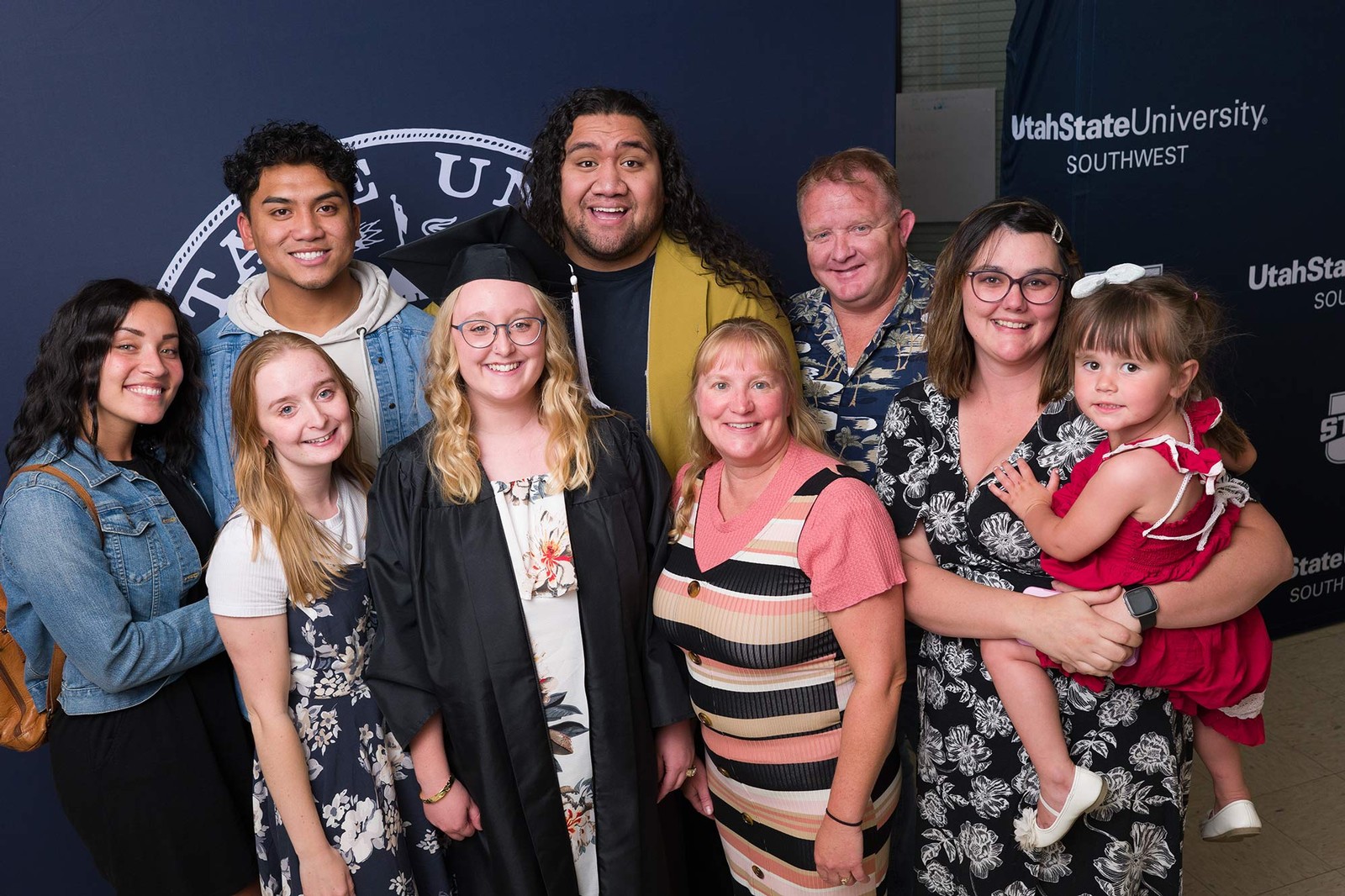 A USU Southwest grad poses for a picture with loved ones.