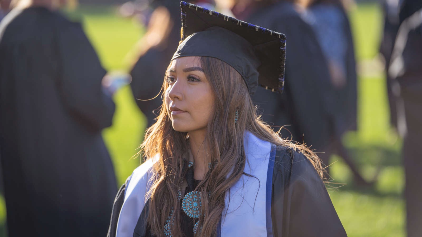   Full Size A woman wears graduation robes at Utah State University Commencement celebrations