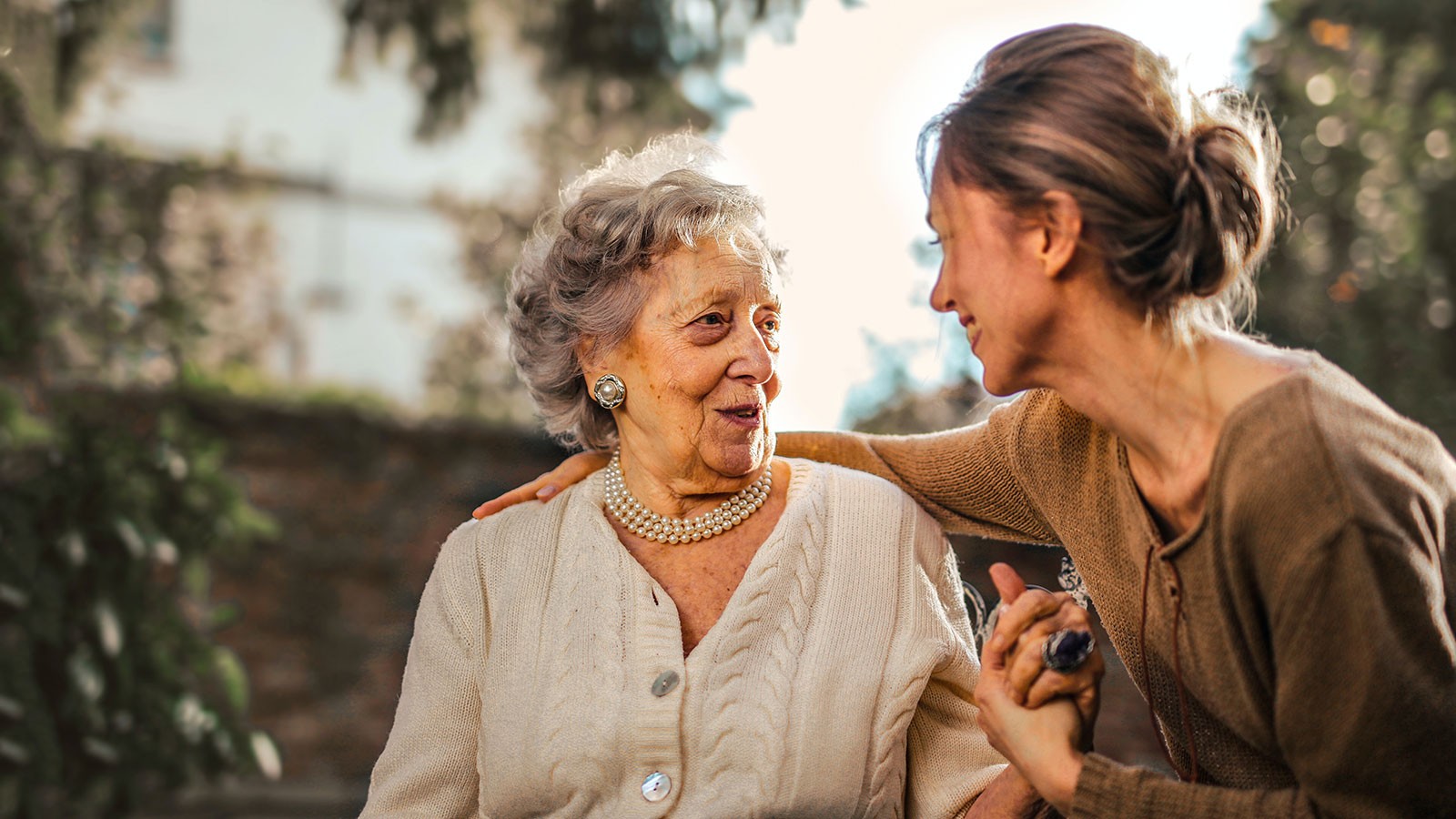 A woman talking with an older woman.