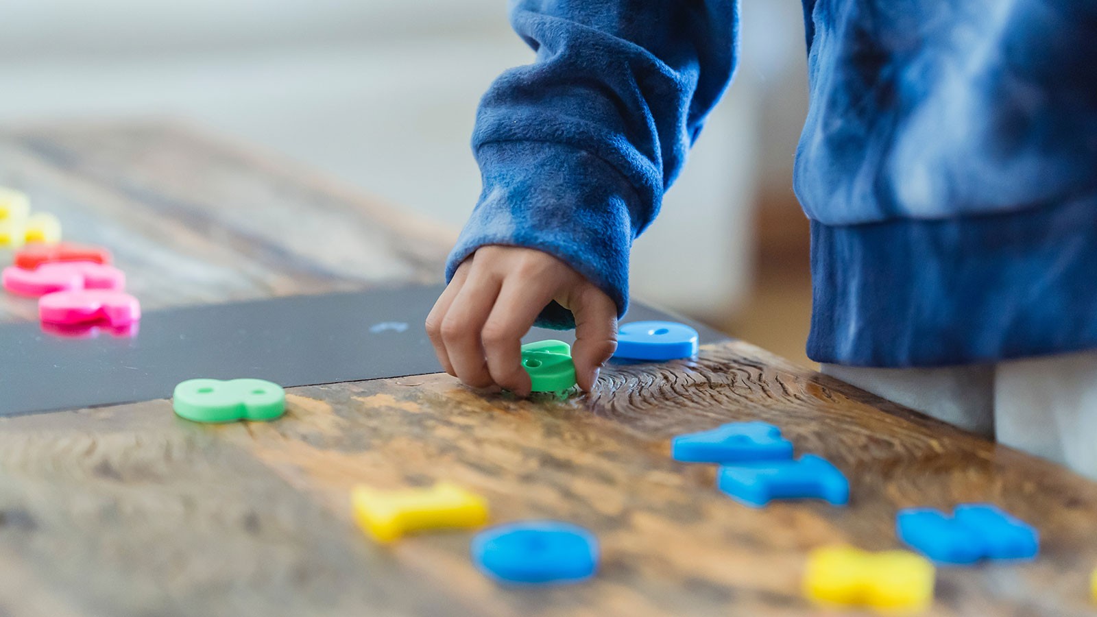 A child playing with magnetic numeral toys.