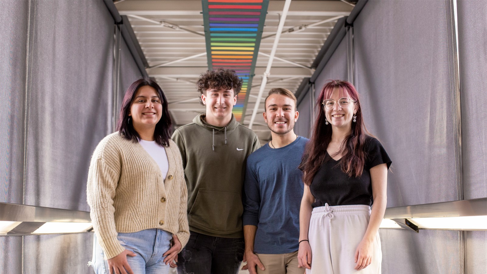 Students in front of a rainbow display.