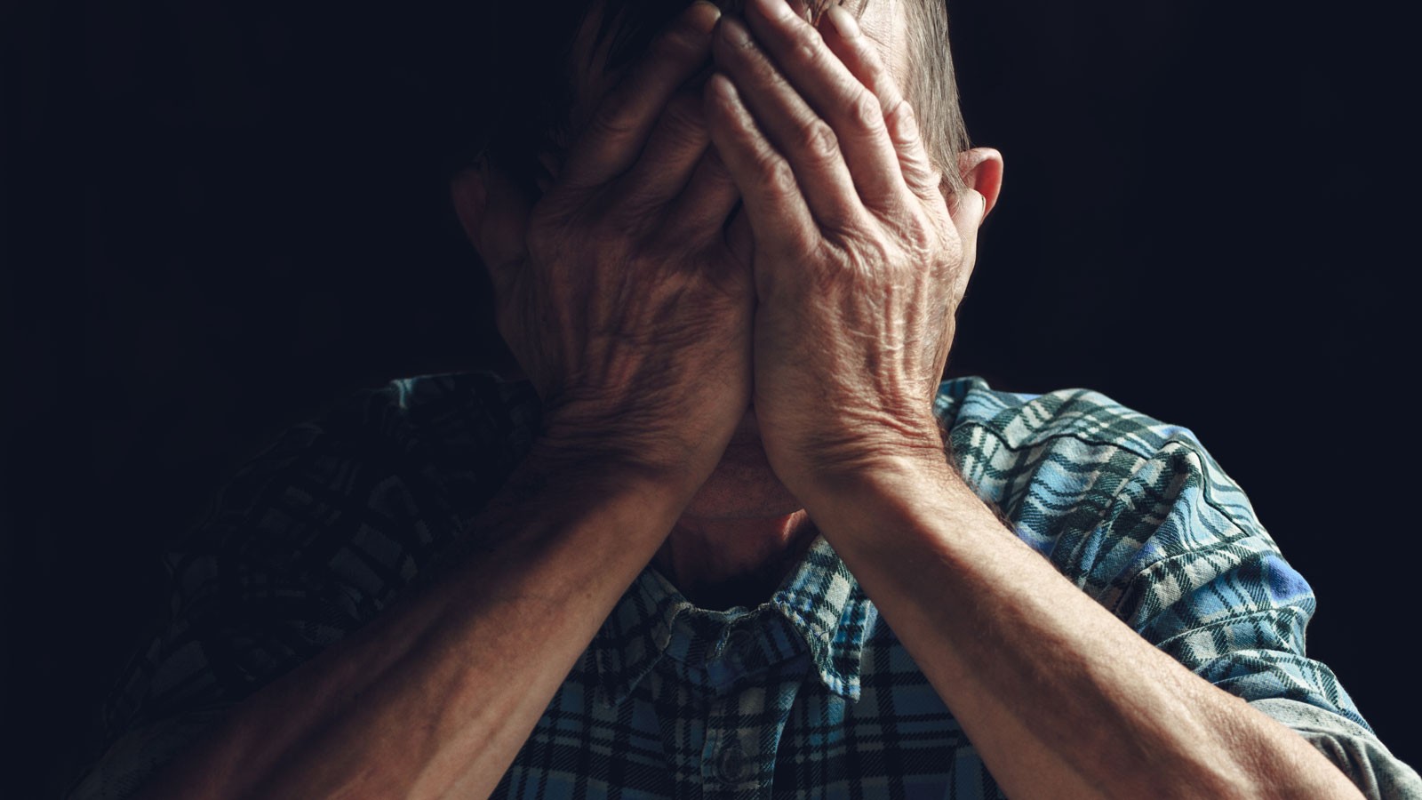 A person holding their head in their hands.