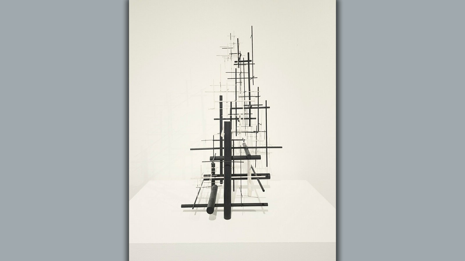 A sculpture of several black and white steel rods intersecting at right angles.