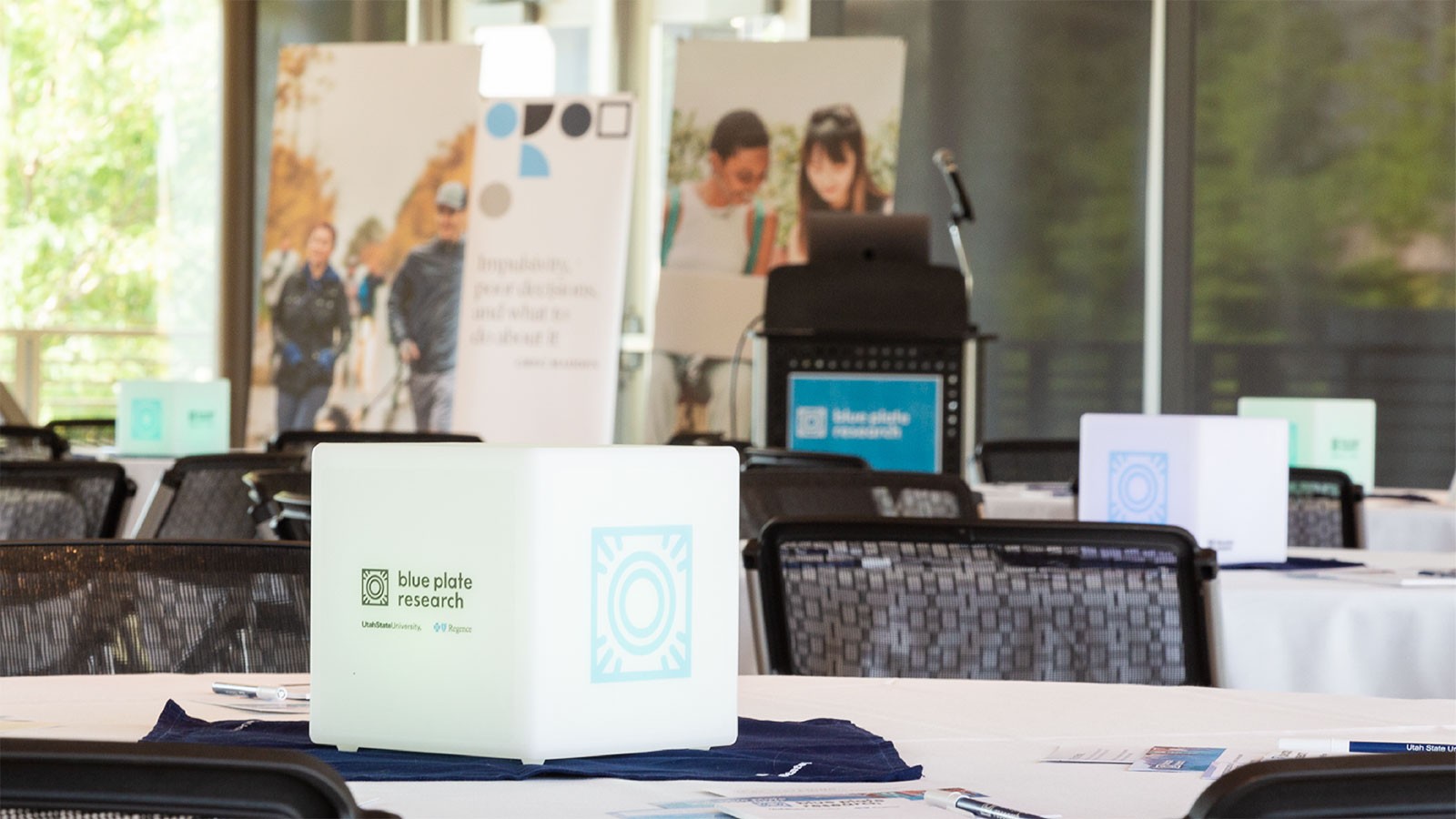 A centerpiece with the words "Blue Plate Research" sits on a table at an event.