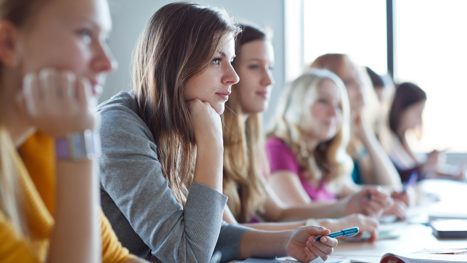 Women taking notes in a classroom.