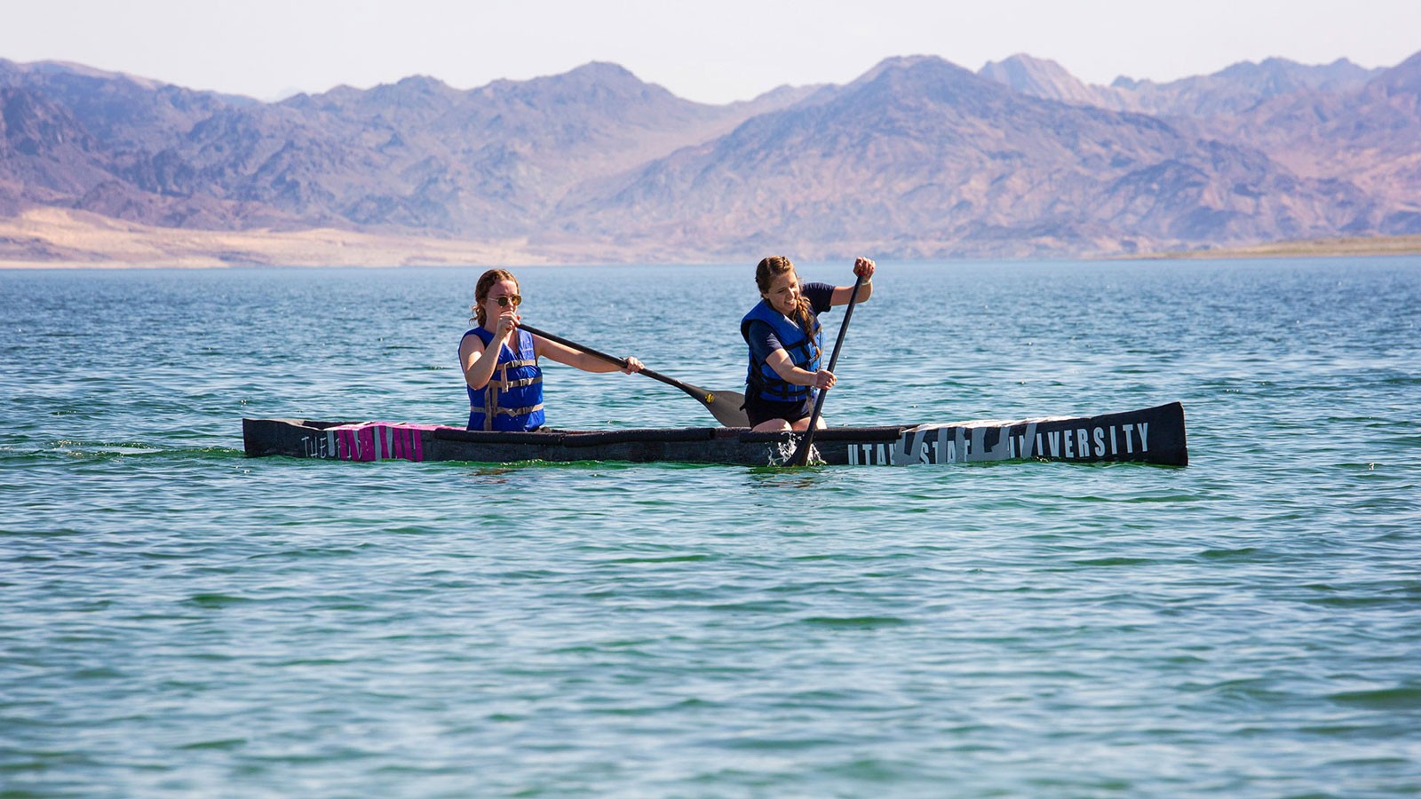 Student paddling a concrete canoe.