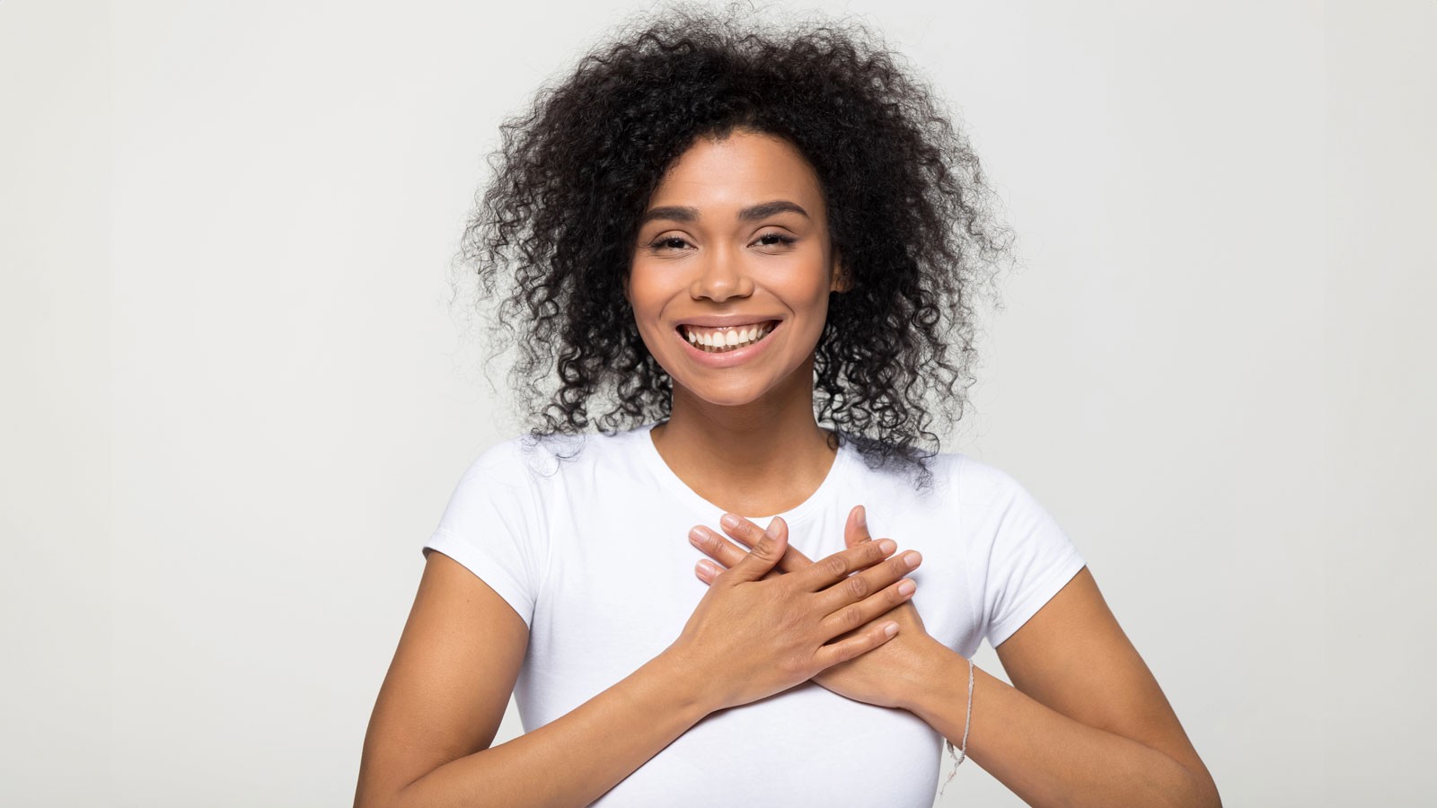 A person holding their hands over their heart.