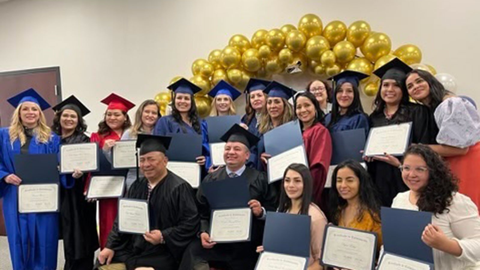 People holding graduation certificates.